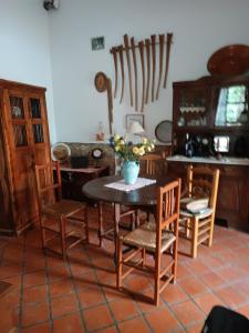 a room with a table with chairs and a vase of flowers at Casa Algiana - Private Pool in Loulé
