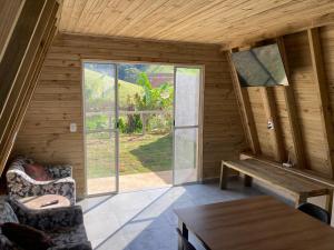 an empty room with a table and a large window at Paraitinga Glamping in São Luiz do Paraitinga