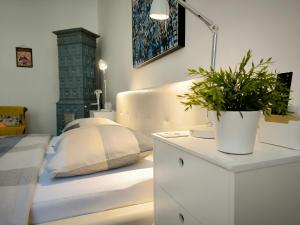 a bedroom with a white bed and a plant on a dresser at Konzul -Top apartment, strict center, parking in Osijek +25 photos