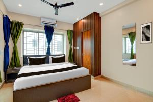 a bedroom with a large bed and a mirror at Hotel O Newtown worldstay in Thākurdwari