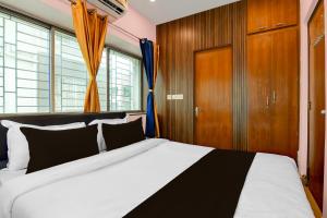 a bedroom with a large bed and a wooden cabinet at Hotel O Newtown worldstay in Thākurdwari