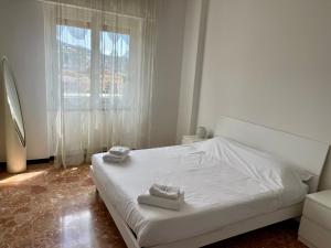 a bedroom with a white bed and a window at Maison Giovanna with garage parking in Rapallo +30 photos