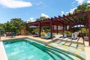 a swimming pool with a pergola and a patio at Serra do Juá Pousada de Campo in Pirenópolis