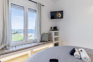 a bedroom with a window with a view of the ocean at Uncle John's Guesthouse in Skopelos Town