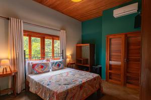 a bedroom with a bed and a green wall at Serra do Juá Pousada de Campo in Pirenópolis +29 photos