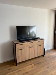 a flat screen tv sitting on top of a wooden dresser at Staufen Stern in Oberstaufen