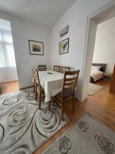 a dining room with a table and chairs on a rug at Al Centro in Peje