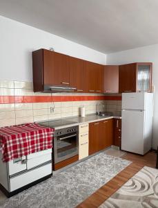 a kitchen with wooden cabinets and a white refrigerator at Al Centro in Peje +10 photos