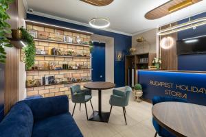 a lobby with a blue couch and a table and chairs at Budapest Holidays Storia in Budapest