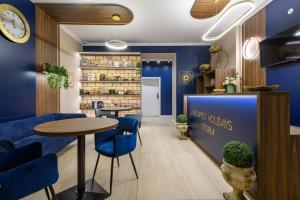 a restaurant with blue walls and a table and chairs at Budapest Holidays Storia in Budapest