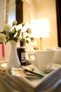 a table with a vase with white flowers and a vase at Relais Forti in Colfiorito