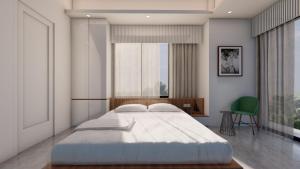 a bedroom with a large bed and a green chair at Hotel Adi International in Rājshāhi