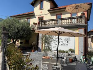 an umbrella and chairs in front of a building at VILLA CHIARA Lago Maggiore in Gravellona Toce +38 photos