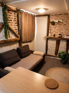 a living room with a couch and a table at Le logis Bressan-cosy-clim in Coligny