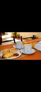 a table with two cups and plates of food on it at Hotel Ke Kuul in Salta +2 photos