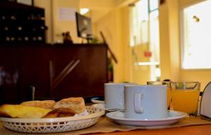 a table with two cups of coffee and bread at Hotel Ke Kuul in Salta