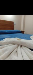 a white blanket laying on top of a bed at Hotel Ke Kuul in Salta