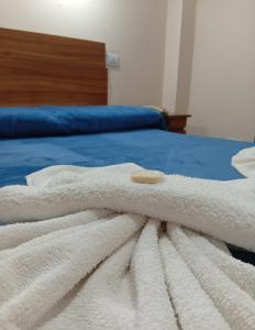a white towel is laying on a bed at Hotel Ke Kuul in Salta