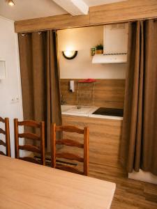 a dining room with a table and chairs and a kitchen at Le logis Bressan-cosy-clim in Coligny +6 photos