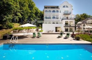 a villa with a swimming pool in front of a house at Appartement Baltic Pearl in Ostseebad Sellin