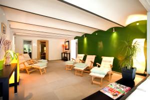 a living room with chairs and a green wall at Appartement Baltic Pearl in Ostseebad Sellin