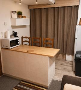 a kitchen with a counter top with a microwave at Le logis Bressan-cosy-clim in Coligny