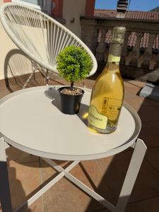 a white table with a bottle of wine and a plant at VILLA CHIARA Lago Maggiore in Gravellona Toce