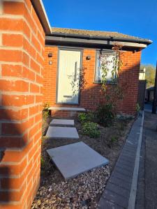 a brick house with a sidewalk in front of it at Studio 3 - Stylish apartment central to hospital and racecourse in Cheltenham