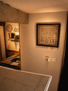 a kitchen with a wall with a picture on the wall at Suite spa Romantique avec piscine privée cosy clim in Coligny