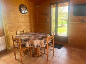 a dining room with a table and chairs and a clock at Le chalet de Pierrot in La Malène +9 photos