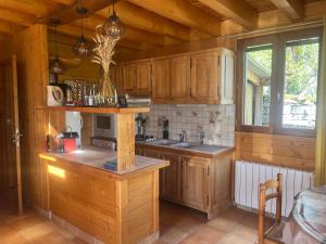 a kitchen with wooden cabinets and a sink at Le chalet de Pierrot in La Malène
