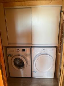 a laundry room with a washing machine and a washer at Le chalet de Pierrot in La Malène