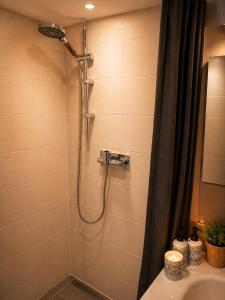 a bathroom with a shower with a shower curtain at Suite spa Romantique avec piscine privée cosy clim in Coligny