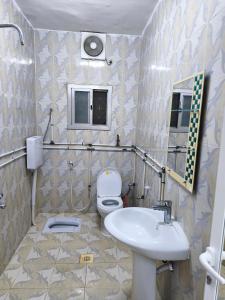 a bathroom with a toilet and a sink at شقة مفروشة بمدينة نزوى in Fulūj Sayghah