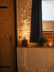 a window with a black curtain and a plant on a ledge at Suite spa Romantique avec piscine privée cosy clim in Coligny +2 photos
