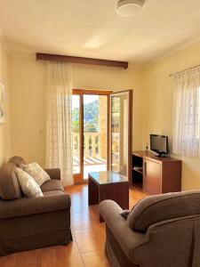 a living room with a couch and a table and a tv at Apartments MUN Petrovac in Petrovac na Moru