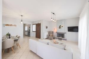 a living room with white furniture and a fireplace at Electras house in Kassandra