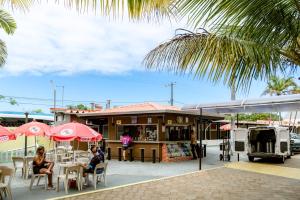 people sitting at tables under umbrellas outside a restaurant at USCEESP Itanhaem in Itanhaém