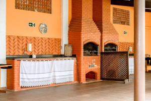 a kitchen with a brick wall with a table and a grill at USCEESP Itanhaem in Itanhaém
