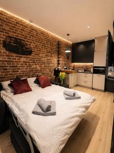 a large bed in a room with a brick wall at Brick Loft Nikiszowiec in Katowice