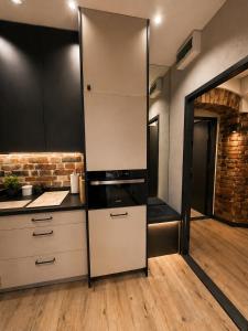 a kitchen with white cabinets and a refrigerator at Brick Loft Nikiszowiec in Katowice +10 photos
