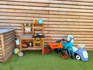 a toy bike and a table in front of a wooden wall at Čajkovskij Apartments in Brno