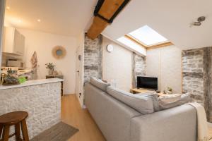 a living room with a couch and a tv at Le studio Bressan-cosy-clim in Coligny