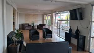 a living room with a couch and chairs and a television at USCEESP Itanhaem in Itanhaém