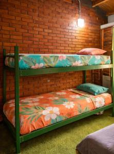 two bunk beds in a room with a brick wall at OlasHostel in Mendoza
