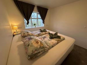 a bedroom with two beds and a window at Hrutafell Guesthouse in Hvolsvöllur