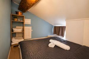 a bedroom with a bed and a shelf with towels at Le studio Bressan-cosy-clim in Coligny