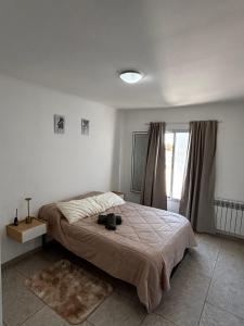 a bedroom with a bed with shoes on it at La Pampa Apartment in General Roca