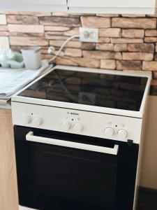 a black and white stove top oven in a kitchen at Зелена долина in Solgutovo