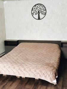 a bed in a room with a tree on the wall at Зелена долина in Solgutovo +21 photos